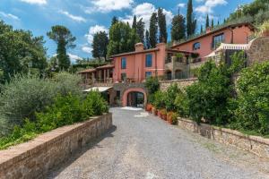 a large pink house on a hill with a driveway at Le Panteraie in Montecatini Terme