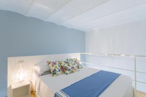 シラクーサにあるSuite 18, casa di charme in Ortigiaの白いベッドルーム(青い毛布付きのベッド付)