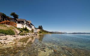 a view of a river with houses on the shore at Hotel Huemul in San Carlos de Bariloche