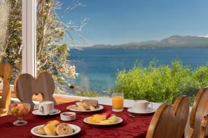una mesa con desayuno y vistas al agua en Hotel Huemul en San Carlos de Bariloche