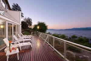 una terraza con sillas y vistas al agua en Hotel Huemul en San Carlos de Bariloche
