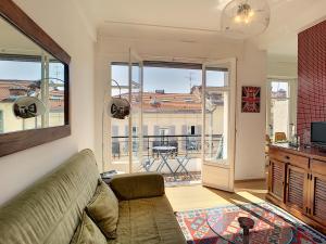een woonkamer met een bank en een balkon bij Nestor&Jeeves - LUGIA - Central - Close sea - Family in Nice
