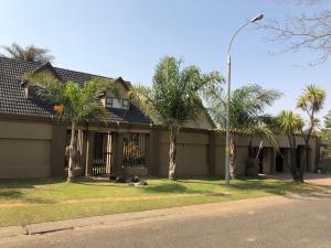 a house with palm trees and a street light at Annie's Place in Kempton Park