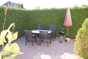a patio with a table and chairs and an umbrella at Ferienhaus Sonnenschein an der Ostsee - ABC235 in Zierow