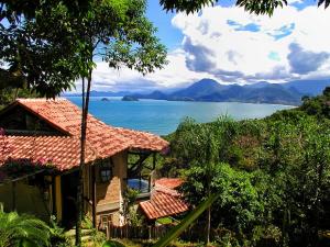 a house with a view of the ocean and mountains at Pousada Casa Milà in Ubatuba