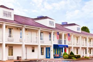 a large white building with american flags at Baymont by Wyndham Tullahoma in Tullahoma