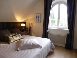 una camera da letto con un grande letto e una finestra di Chambres d'hôtes La ParentheZ' a Haguenau