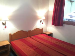 1 dormitorio con 1 cama con sábanas rojas y 2 lámparas en T3 Les deux Alpes Vallée Blanche en Les Deux Alpes