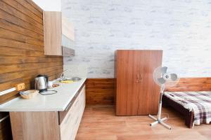 a kitchen with a counter and a sink and a bed at Tsentr Hostel in Vinnytsya