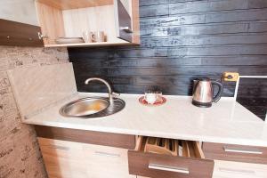 a kitchen counter with a sink and a kettle at Tsentr Hostel in Vinnytsya