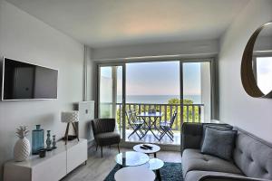 a living room with a couch and a view of the ocean at Les Terrasses du parc Cordier in Trouville-sur-Mer