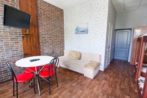 a room with a table and chairs and a couch at Tsentr Hostel in Vinnytsya