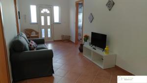 a living room with a couch and a tv at Casa D'Avó (R/C) in Altura