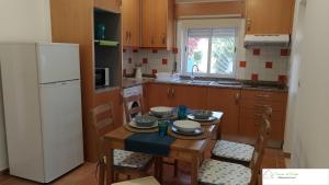 a kitchen with a table and chairs and a refrigerator at Casa D'Avó (R/C) in Altura