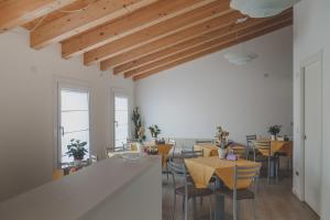 comedor con mesas y sillas y techos de madera en Terra Ferma Rooms&More, en Salzano