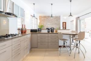 Una cocina con gabinetes blancos y una mesa con sillas. en Superbe Villa privée, en Flic en Flac