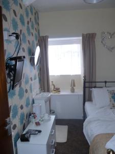 a bedroom with a bed and a desk with a sink at Belle Vue Hotel in Llanwrtyd Wells