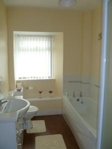 a bathroom with a sink and a toilet and a tub at Belle Vue Hotel in Llanwrtyd Wells