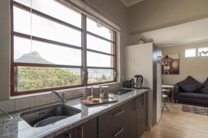 a kitchen with a sink and a large window at 11 Deerpark Drive East in Cape Town