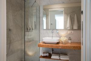 a bathroom with a sink and a glass shower at Domus Sansevero in Naples