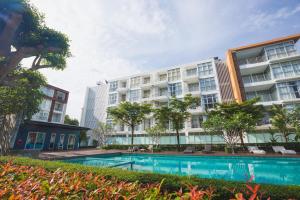 Un edificio de apartamentos con piscina enfrente. en At Seacondo-2 Bedrooms-B35, en Klong Muang Beach