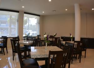 - une salle à manger avec des tables, des chaises et des fleurs dans l'établissement Hotel America, à Tijuana