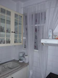 uma cozinha com um lavatório e uma janela com cortinas em Αnna's Home!!!Holidays in beautiful Athens em Atenas