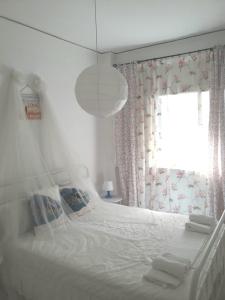 - une chambre avec un lit blanc et une fenêtre dans l'établissement Αnna's Home!!!Holidays in beautiful Athens, à Athènes