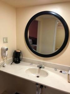 a bathroom with a sink and a mirror at Scottish Inn and Suites Perry in Perry