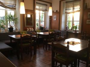 una sala da pranzo con tavoli, sedie e finestre di Hotel zur Eiche a Oberthal