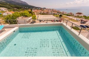 a swimming pool on the roof of a building at Ringo Apartments in Podstrana