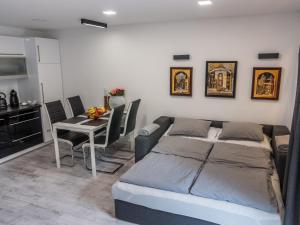 a bedroom with a bed and a table with chairs at Lóczy Apartman in Balatonfüred