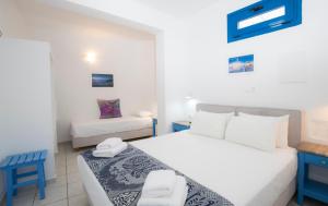 a bedroom with two beds with blue and white at Edem in Fira