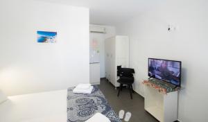 Camera bianca con TV e sedia di Edem a Firà