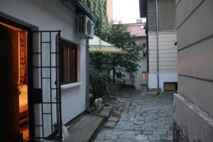 un callejón con un edificio y un gato sentado al lado de un edificio en Apartman Rale, en Belgrado