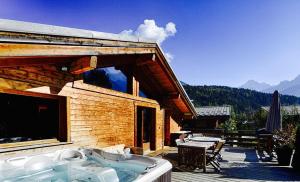 uma cabina de madeira com uma banheira num deque em Chalet 4C em Les Houches