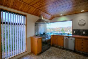a kitchen with a stove and a large window at Best On Bills in Wanaka