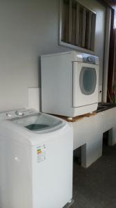 a microwave sitting on top of a washing machine at Apartamento Exclusivo - Hospedes in Joinville