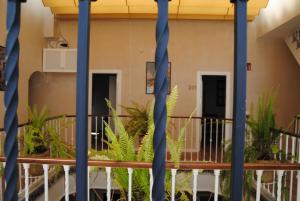 uma varanda com plantas e postes azuis em Pensión Córdoba em Sevilha
