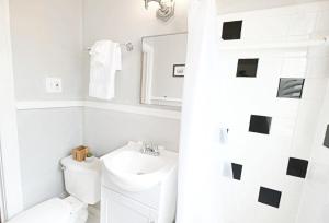 een witte badkamer met een wastafel en een toilet bij Fresh + Bright 1 BR Flat | Free Parking in Dallas