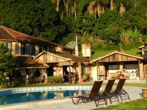 a group of chairs sitting in front of a house at Canto de Roca Turismo e Lazer in Mimoso do Sul
