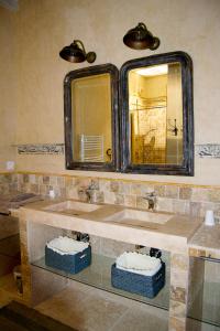 uma casa de banho com 2 lavatórios e um espelho em GITE de la RENAISSANTE em Peyrins