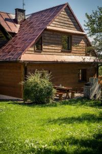 ein Haus mit einem Dach und einem Picknicktisch im Hof in der Unterkunft Gościniec Tokarzonka in Istebna