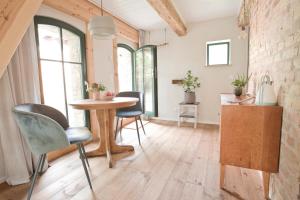 a kitchen with a table and chairs in a room at Scheune de Lütt - Kleine Scheune ganz groß am Rande der Schorfheide - Natur pur in Marienwerder