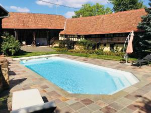 a swimming pool in front of a house at Le gîte des écureuils in Schalkendorf