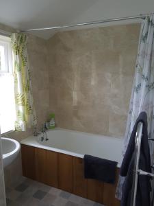 a bathroom with a bath tub and a sink at Laich Cottage in Appin +34 photos