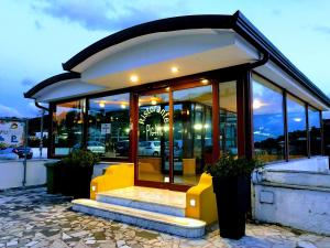 a restaurant with yellow seats in front of a building at De Maria House in SantʼAgata sui Due Golfi