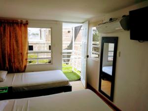 a bedroom with two beds and a large window at Hotel Jardin De Tequendama in Cali