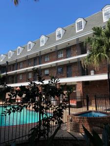 - un bâtiment avec une piscine en face dans l'établissement Midtown Hotel New Orleans, à La Nouvelle-Orléans