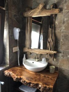 baño con lavabo en una encimera de madera con espejo en Las Cavernas Del Bisonte en Santillana del Mar
